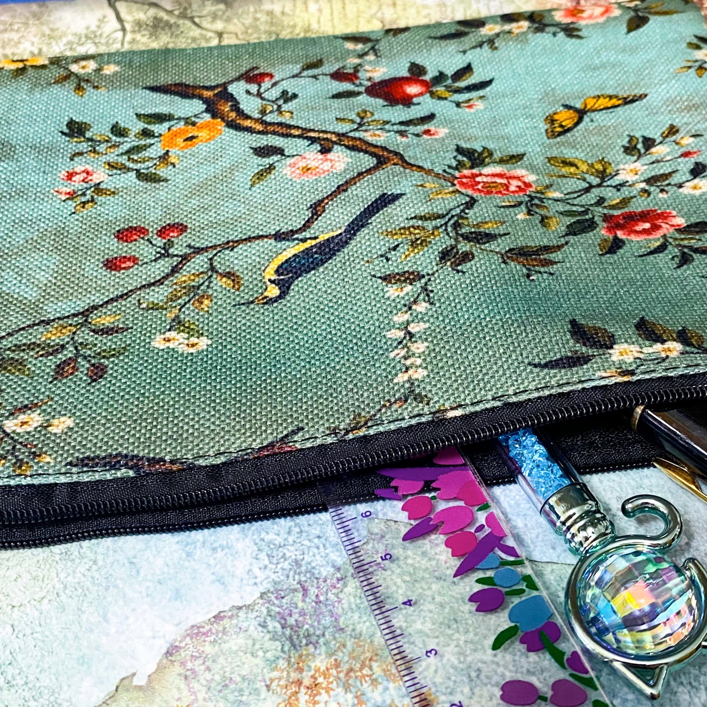 vintage botanical canvas cosmetic pouch featuring a song bird, flowers, butterflies and berries on a sage turquoise soft green blue background with black zip fastening. for journaling, scrapbooking and cosmetics. uk cute letterbox gifts shop.