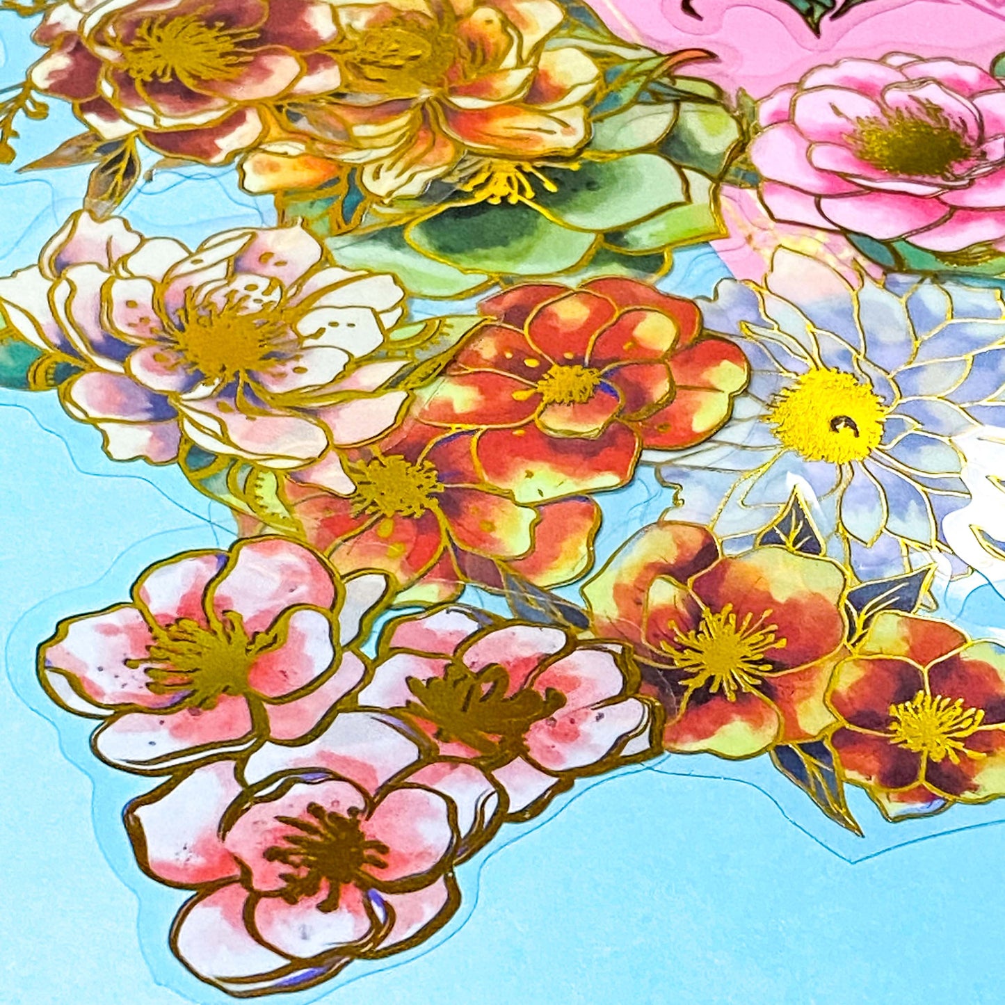assorted large gold foil floral stickers on a turquoise background