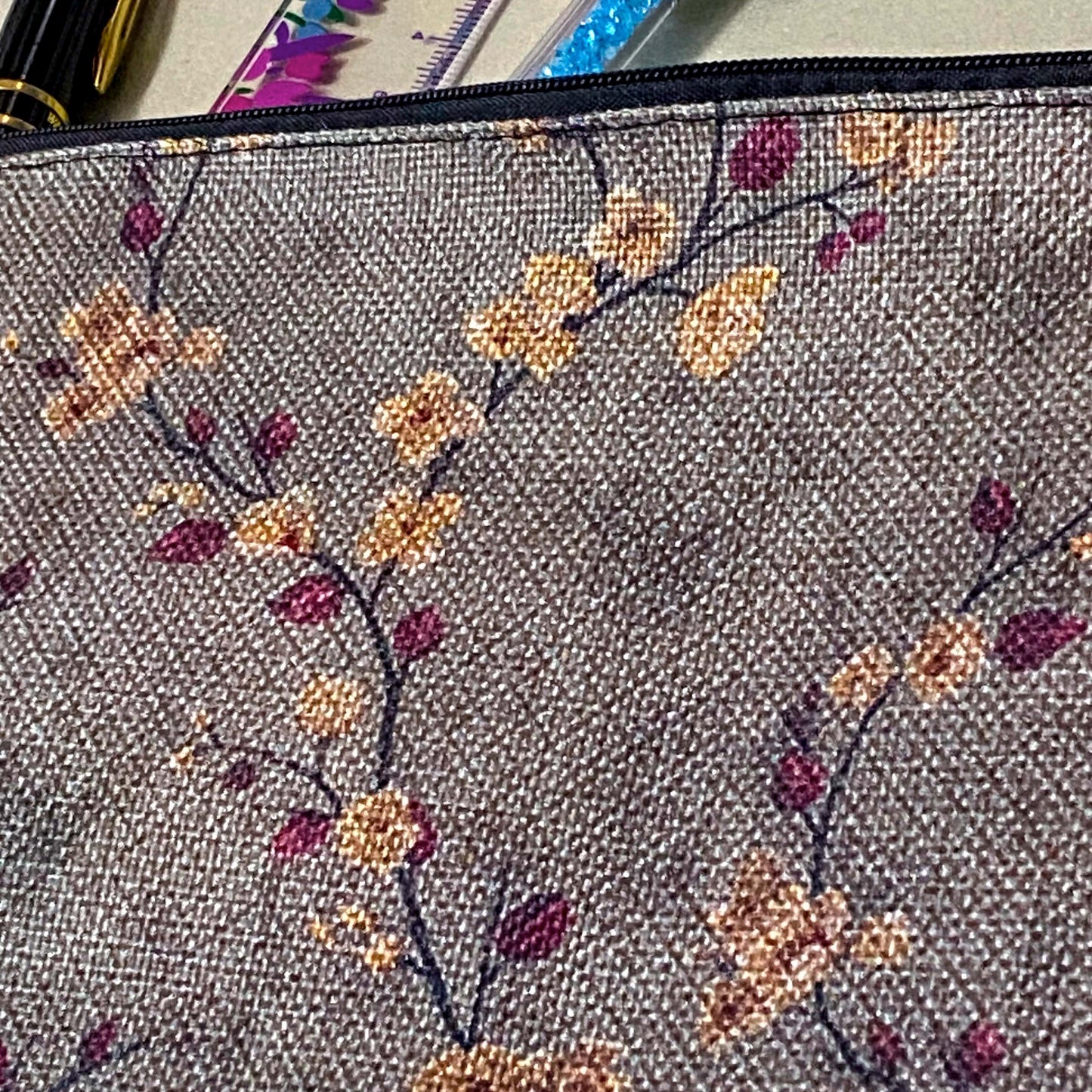autumn hedgerow floral canvas pouch with taupe background, creamy flowers and burgundy rose hips, zip fastening and textured fabric. For journaling, pencil case or cosmetic bag. Uk gifts shop.