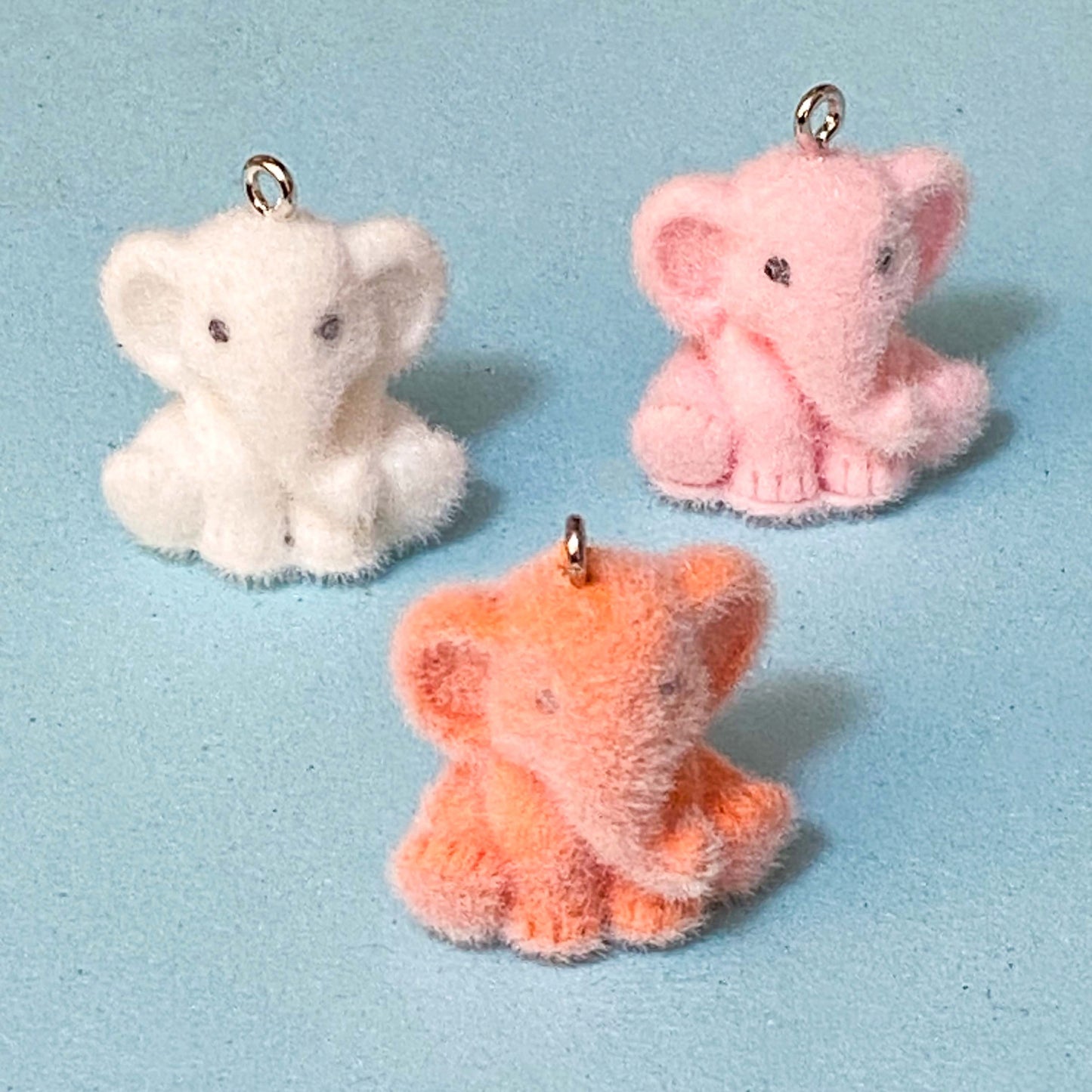 elephant flocked resin charms on a blue background