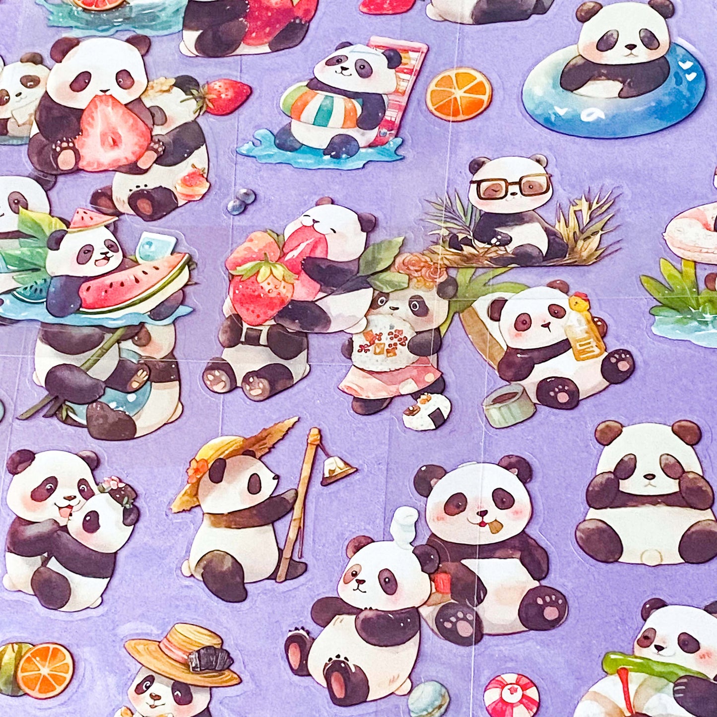close up of clear plastic sticker sheets with cute panda illustrations on a purple background
