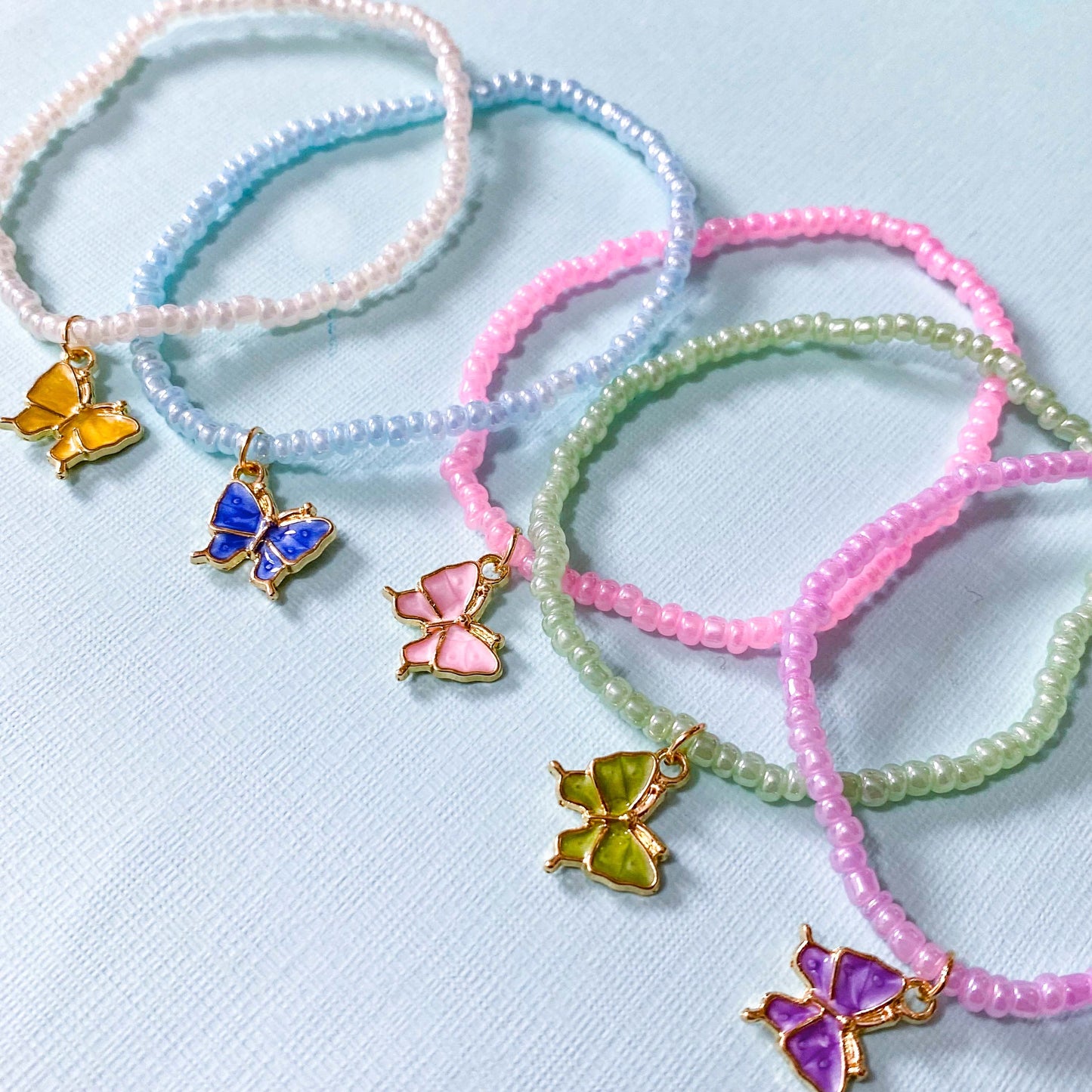 pearl pearly stretch bead bead beaded bracelet bracelets with enamel butterfly charm pendant pink white blue green lilac purple yellow uk cute kawaii gift gifts shop store small delicate present butterflies seed