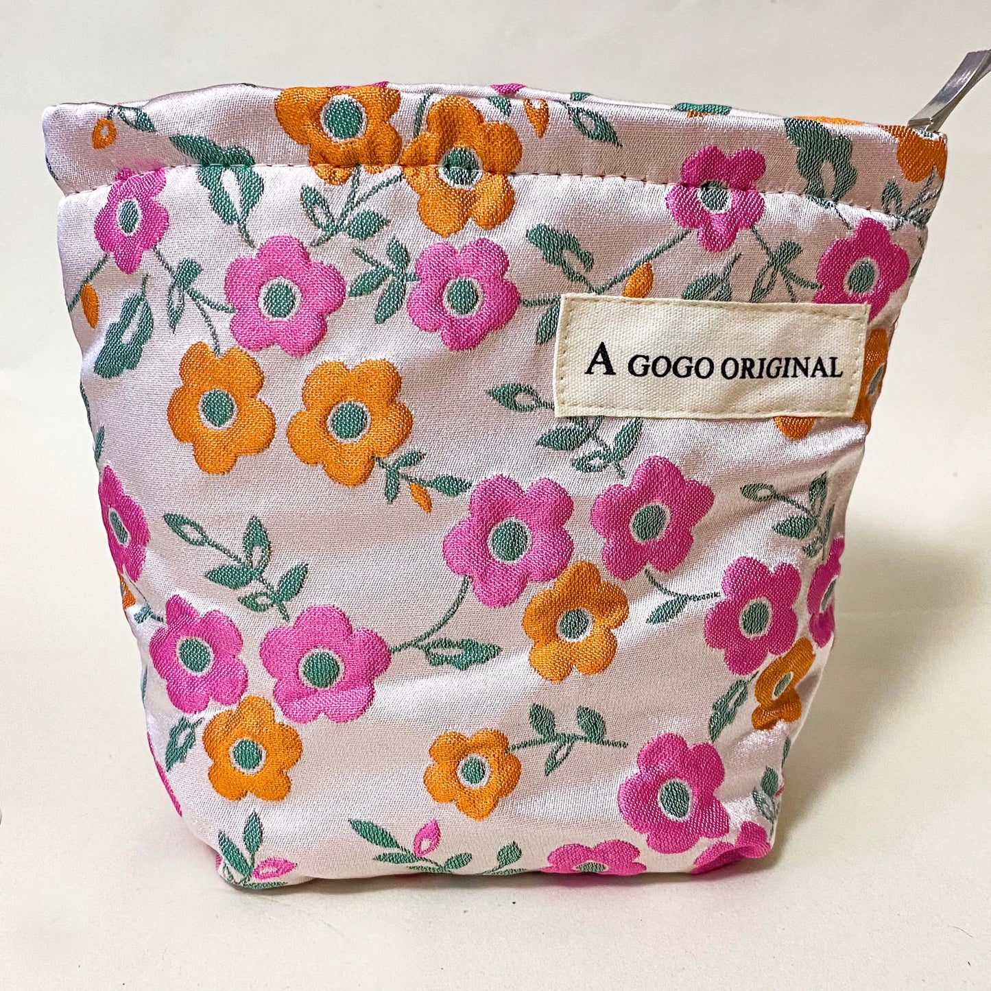 premium woven retro blossom lane cosmetic pouch with pink and coral orange floral design, cream lining and concealed zip. Small bucket shape make up bag. uk letterbox gifts for flower lovers.