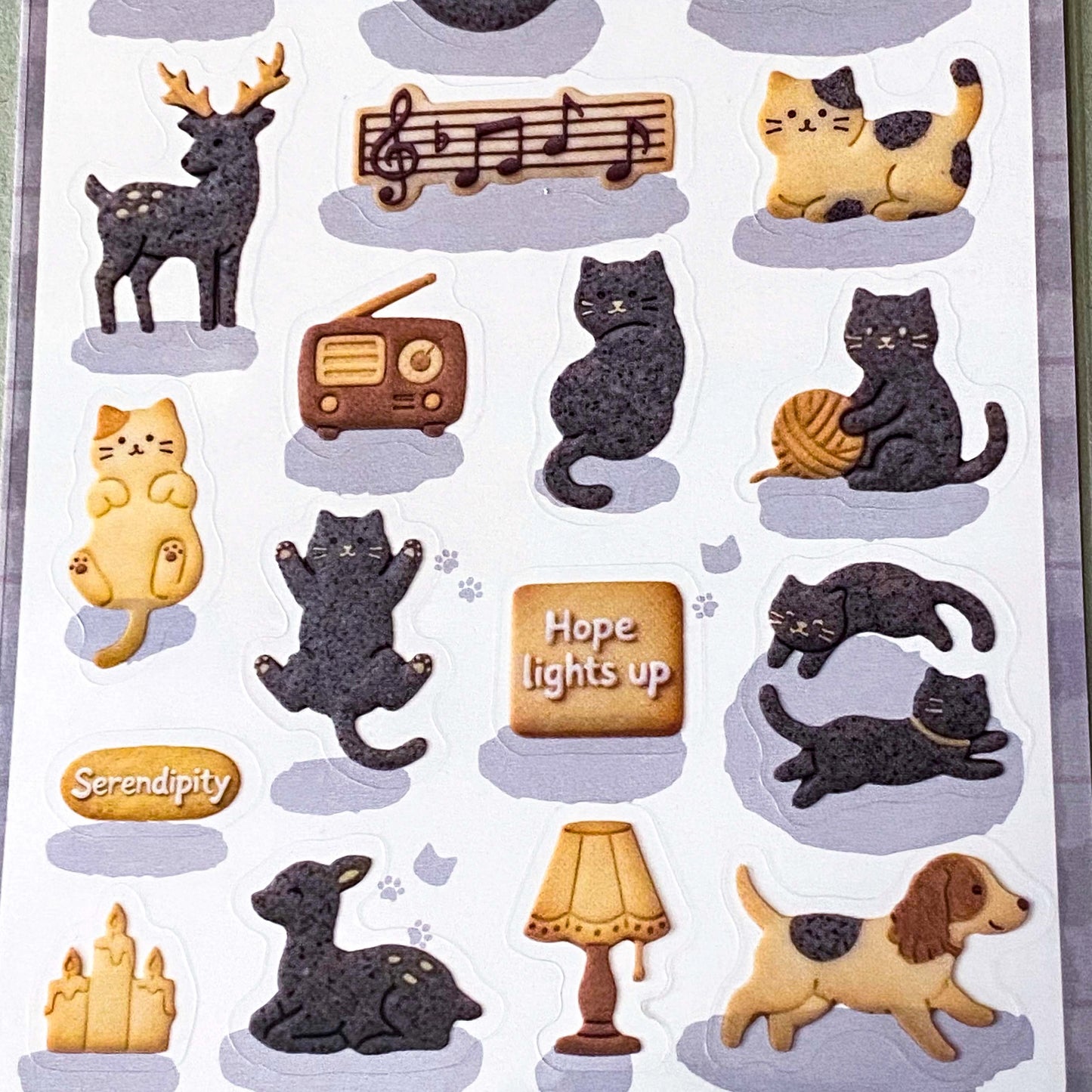 pack of dark grey and caramel coloured cat stickers with household objects and cookie shapes. Fun kawaii stationery pack of 2 transparent PET sheets.