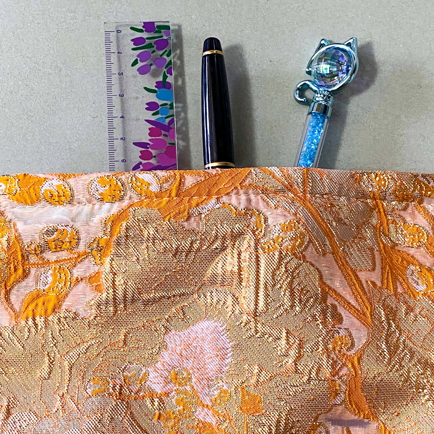 peaches and cream warm orange and gold metallic thread woven tapestry pouch for make up and beauty essentials. fully lined in cream with a concealed zip. floral pattern small fabric cosmetic bag. uk letterbox gifts.