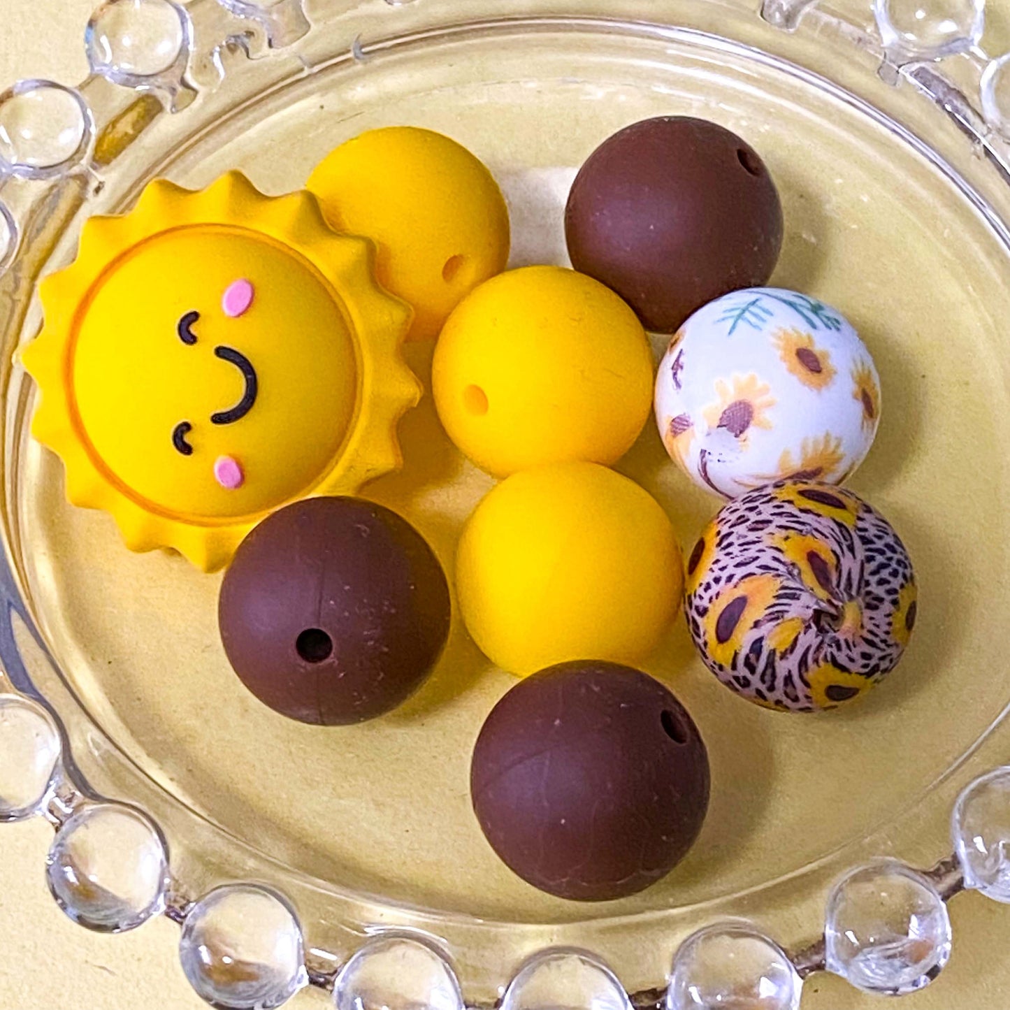 sunny yellow and dark brown silicone beads mix with sunshine jumbo 27mm focal bead and patterned sunflower design 16mm beads. uk craft supplies shop.