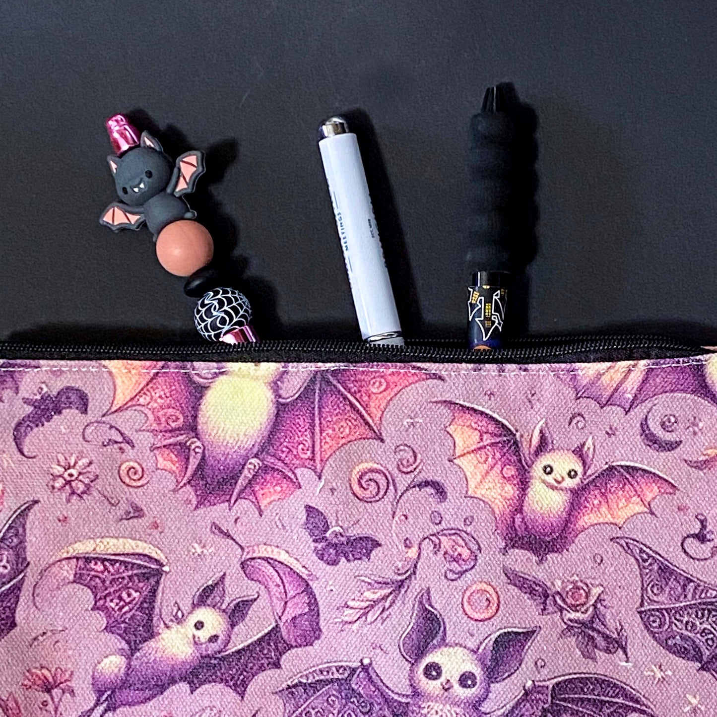rosewing bats fabric zip pouch featuring whimsical pink and plum purple bats amongst flowers and feathers and moonlit details on a blush pink background. uk cosmetic bags from letterbox gift shop.