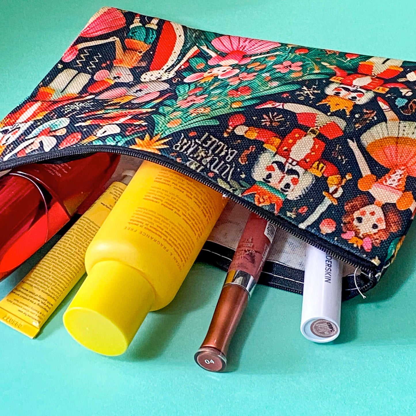 large woven nutcracker ballet zip canvas pouch featuring ballerinas, royal nutcrackers, dancing mice, a decorated Christmas tree and festive illustrations on black background