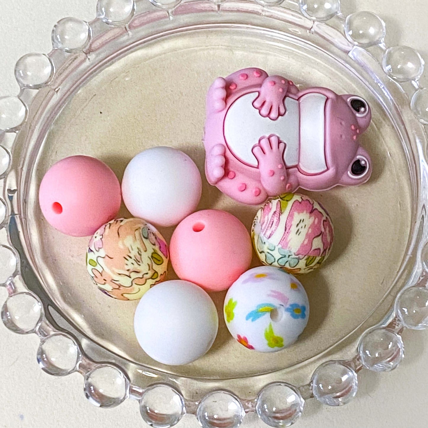 bundle of pretty pink frog silicone beads with focal 33mm frog bead and 7 other plain and patterned beads in floral pinks and white. uk craft supplies shop.