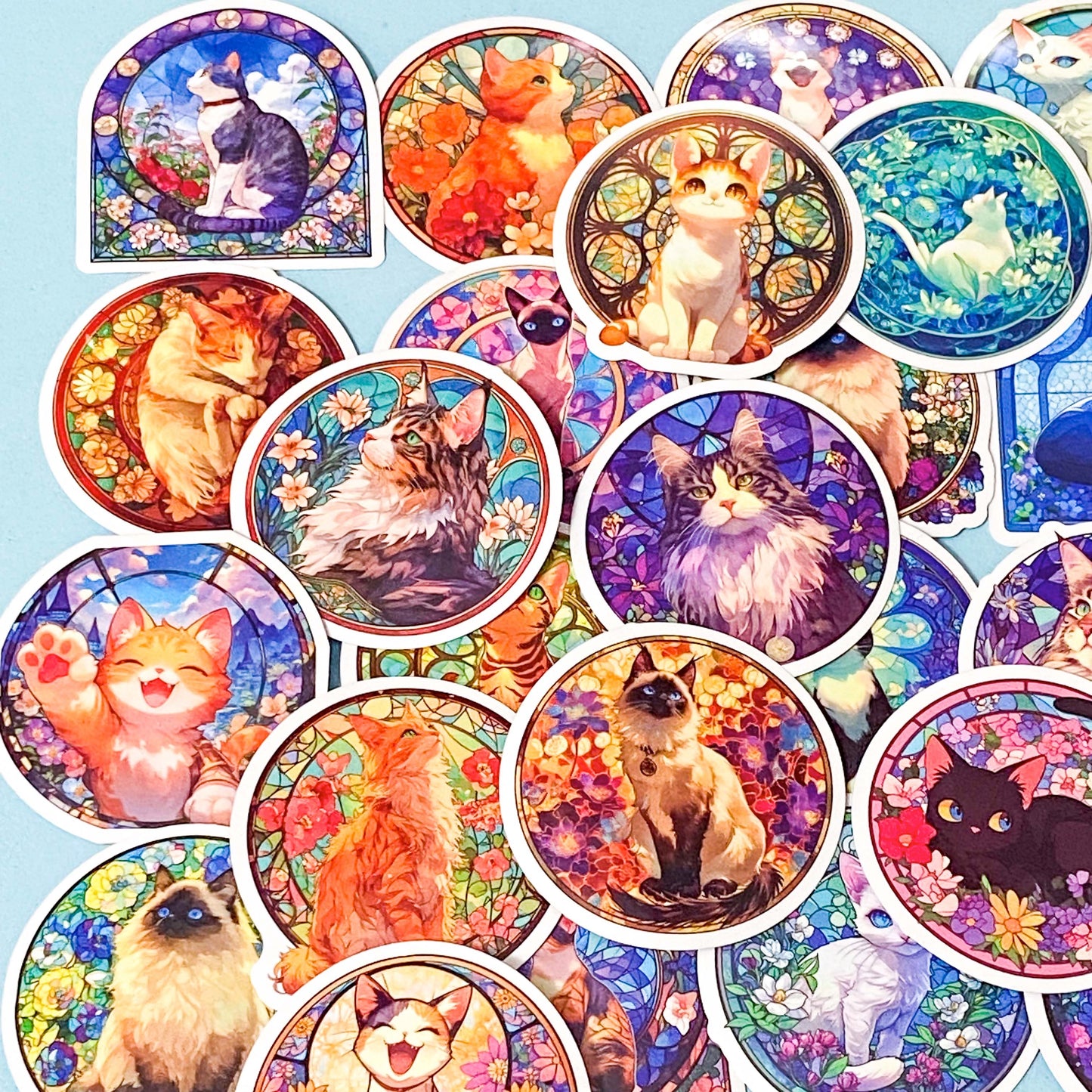 Collection of colorful cat-themed stained glass window laptop stickers on a blue background