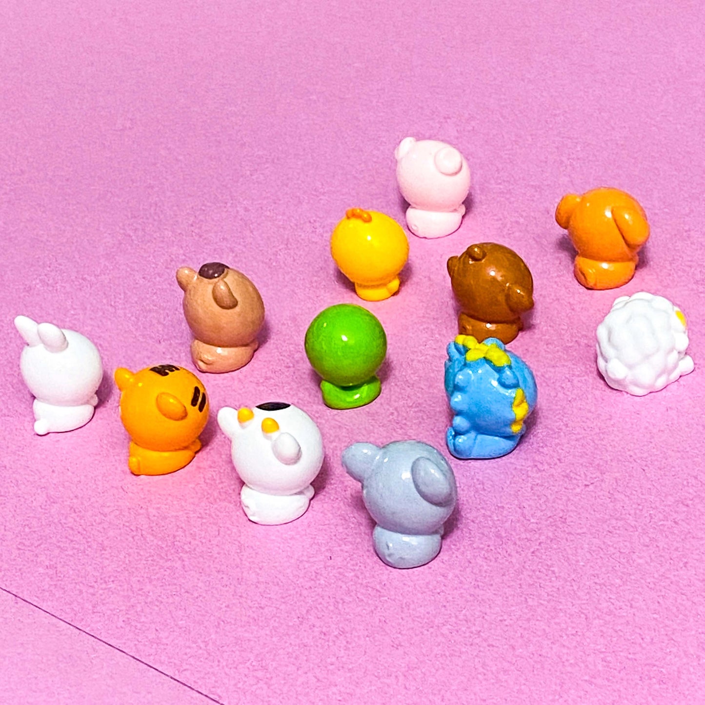 Colorful toy figures on a pink background