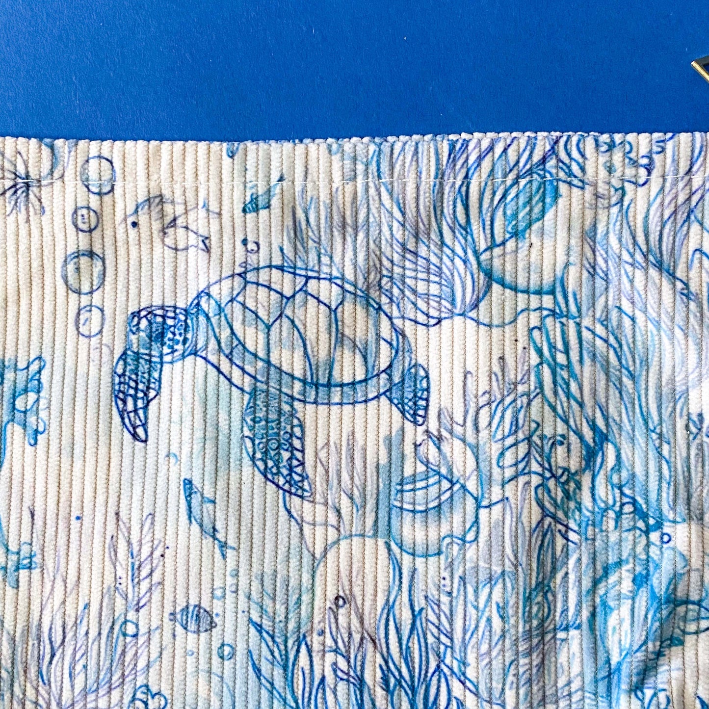 white and pale blue corduroy zip pouch with an underwater illustration featuring sea turtles, fish, marine plants. It is fully lined with waterproof fabric and finished with a sturdy metal zip. uk letterbox gift shop.