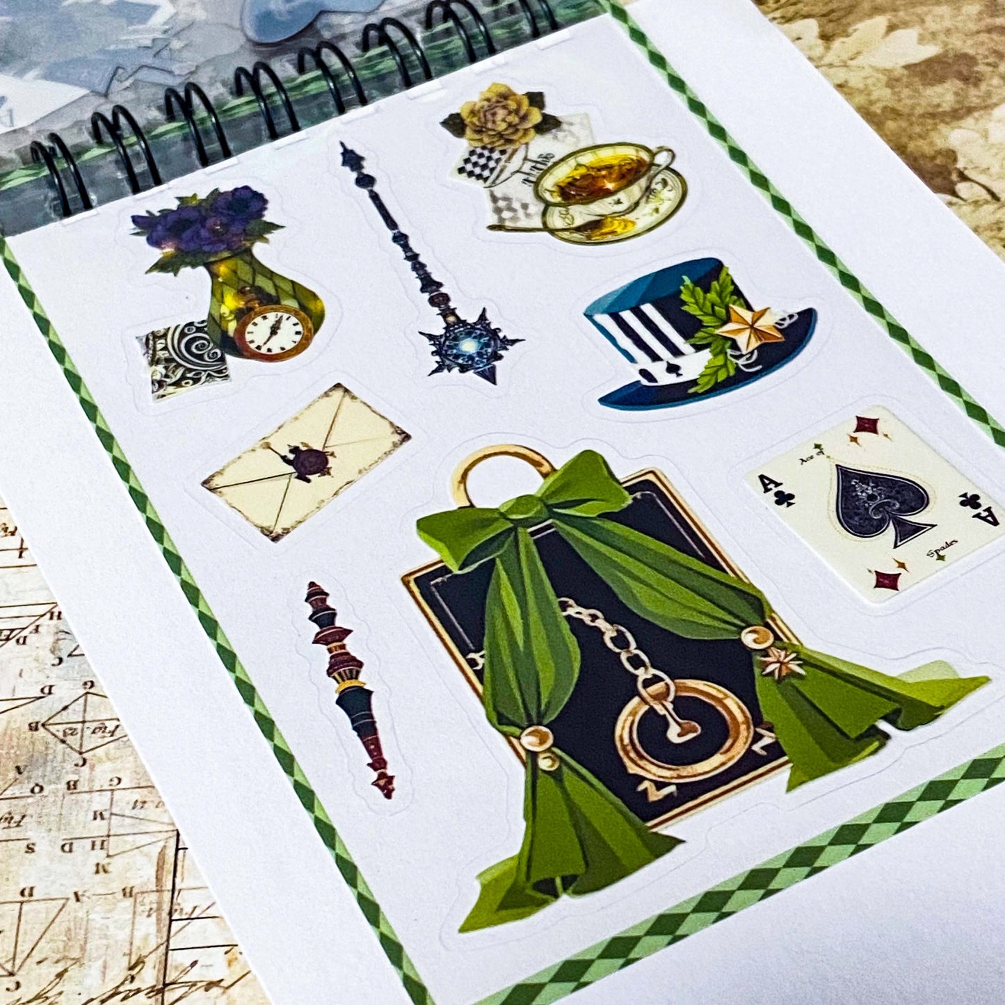 small spiral bound curiouser and curiouser alice clear PET sticker folio featuring fantasy stickers with mushrooms, roses, playing cards, rabbits and vintage gothic fairytale artwork