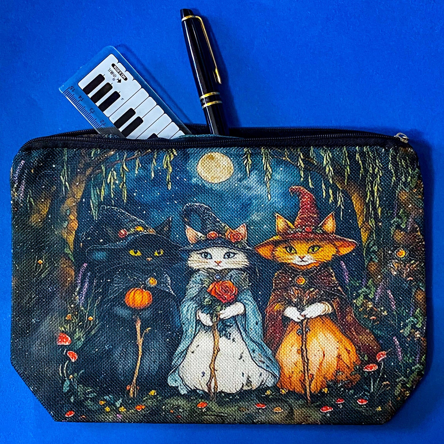 textured canvas pouch featuring three witch cats gathering beneath a full moon in an enchanted woodland with willow branches, mushrooms and autumn leaves. Dark blue, green, storm grey and black. Uk letterbox gifts. Halloween theme.