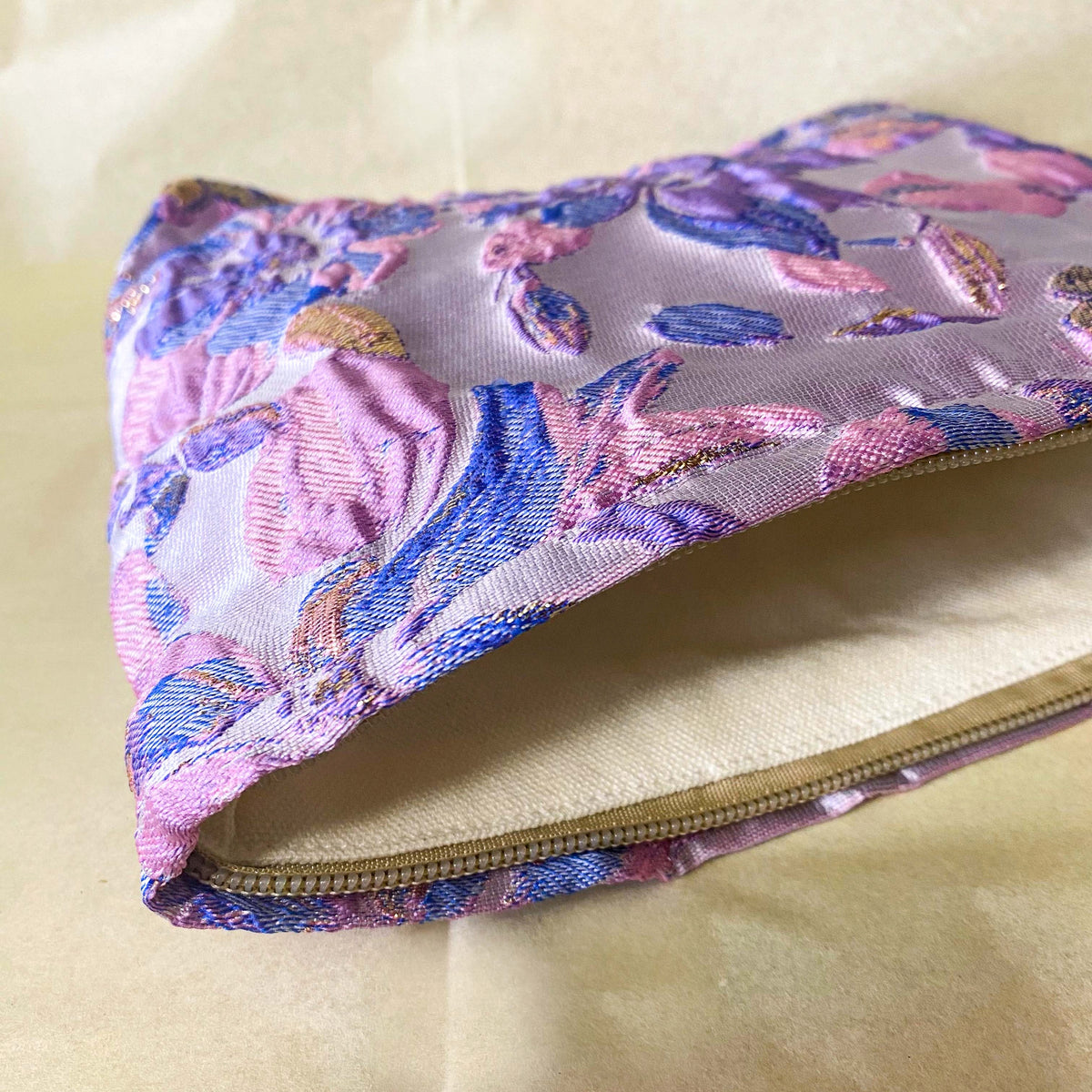 lavender, pink and gold satin tapestry pouch with woven floral design, cream lining, concealed zip and structured gusset base. Pastel large cosmetic bag or jewellery pouch. Journaling storage or travel essentials case. Uk gift shop for letterbox gifts.