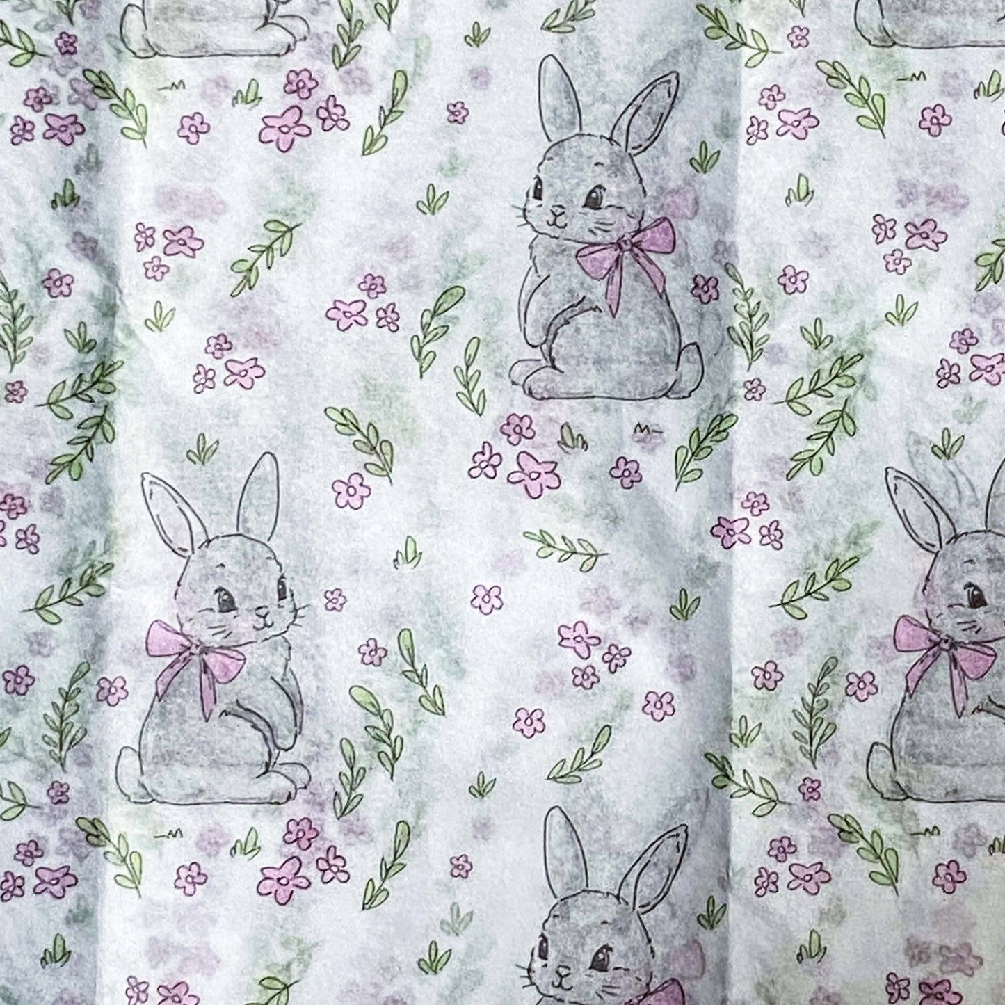 tissue paper with a pattern of grey bunnies with pink bows on a floral background