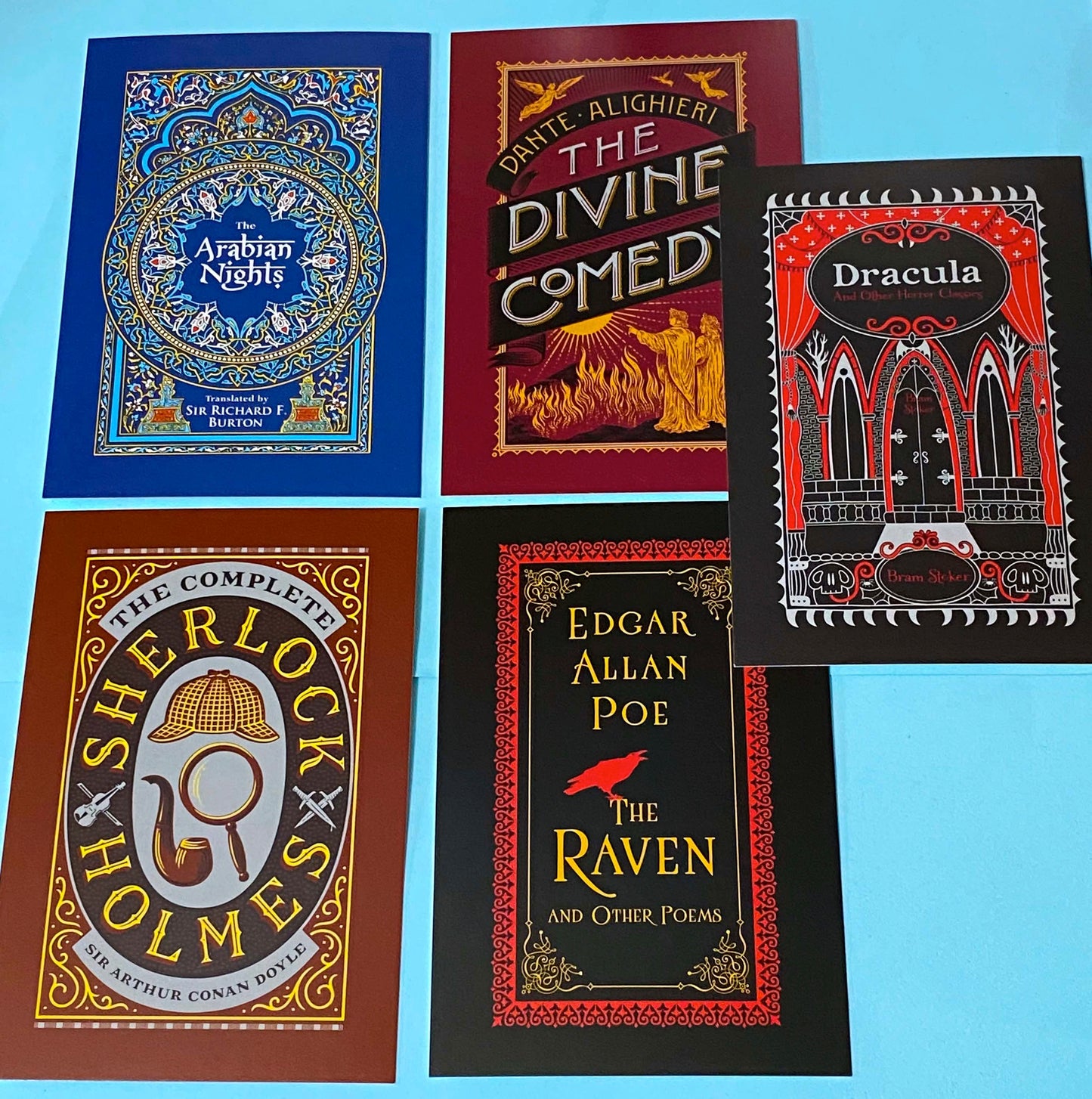 set of 5 vintage literary postcards featuring gothic book covers including dracula, sherlock holmes, dante divine comedy, edgar allan poe on a blue background