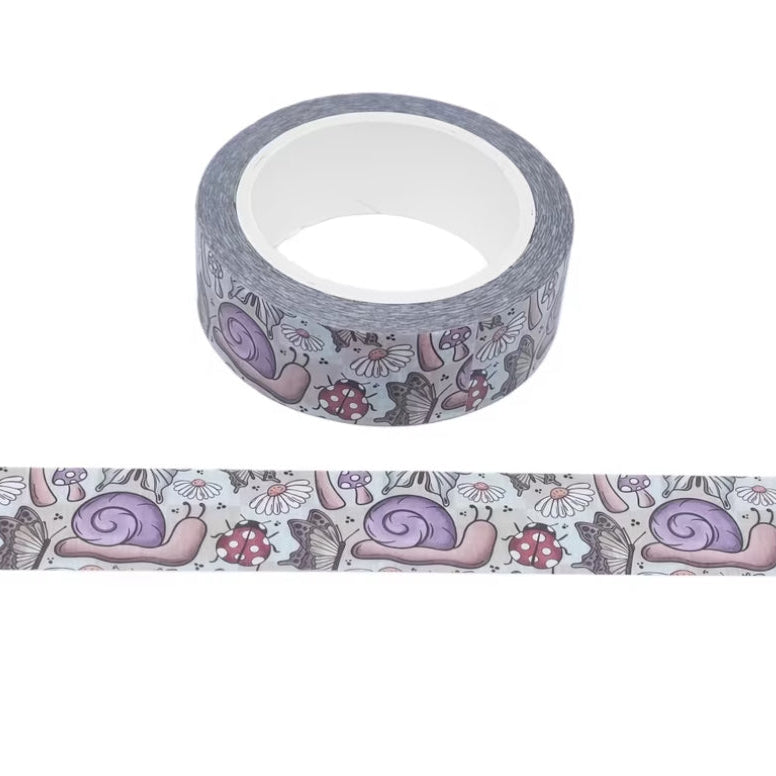 A roll of decorative washi tape with a repeating pattern of purple snails, mushrooms, and ladybugs on a white background, with a horizontal strip of the tape shown below.