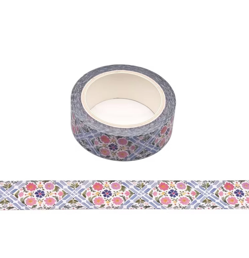 A roll of 10m decorative washi tape with a blue-gray geometric grid background and a repeating floral pattern in pink, purple, and green, shown with a horizontal strip preview below on a white background.