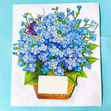 3d pop up card of a basket of blue forget me nots and butterflies on a blue background