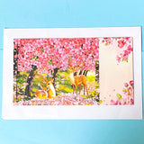 3d pop up card with baby deer in the woods under pink cherry blossom on a blue background