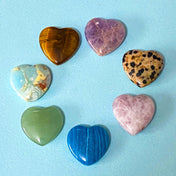 heart shaped gem gemstones carved small palm stones and anxiety gifts on a blue background
