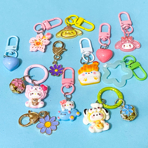 mixed bundle of resin and metal bag charms and keyrings on a blue background