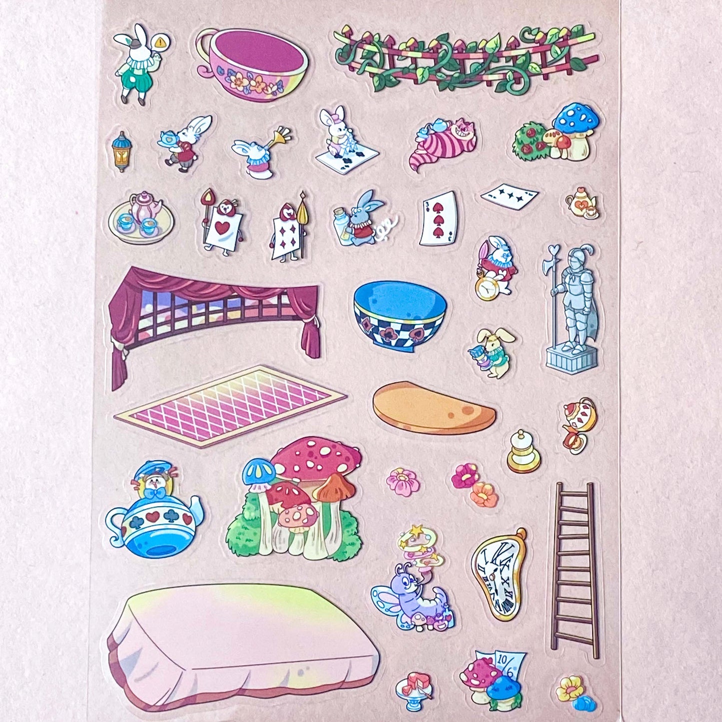 alice in wonderland sticker scene set with background card sheet and clear decorative stickers including teacup, playing cards and fantasy objects. activity creative set