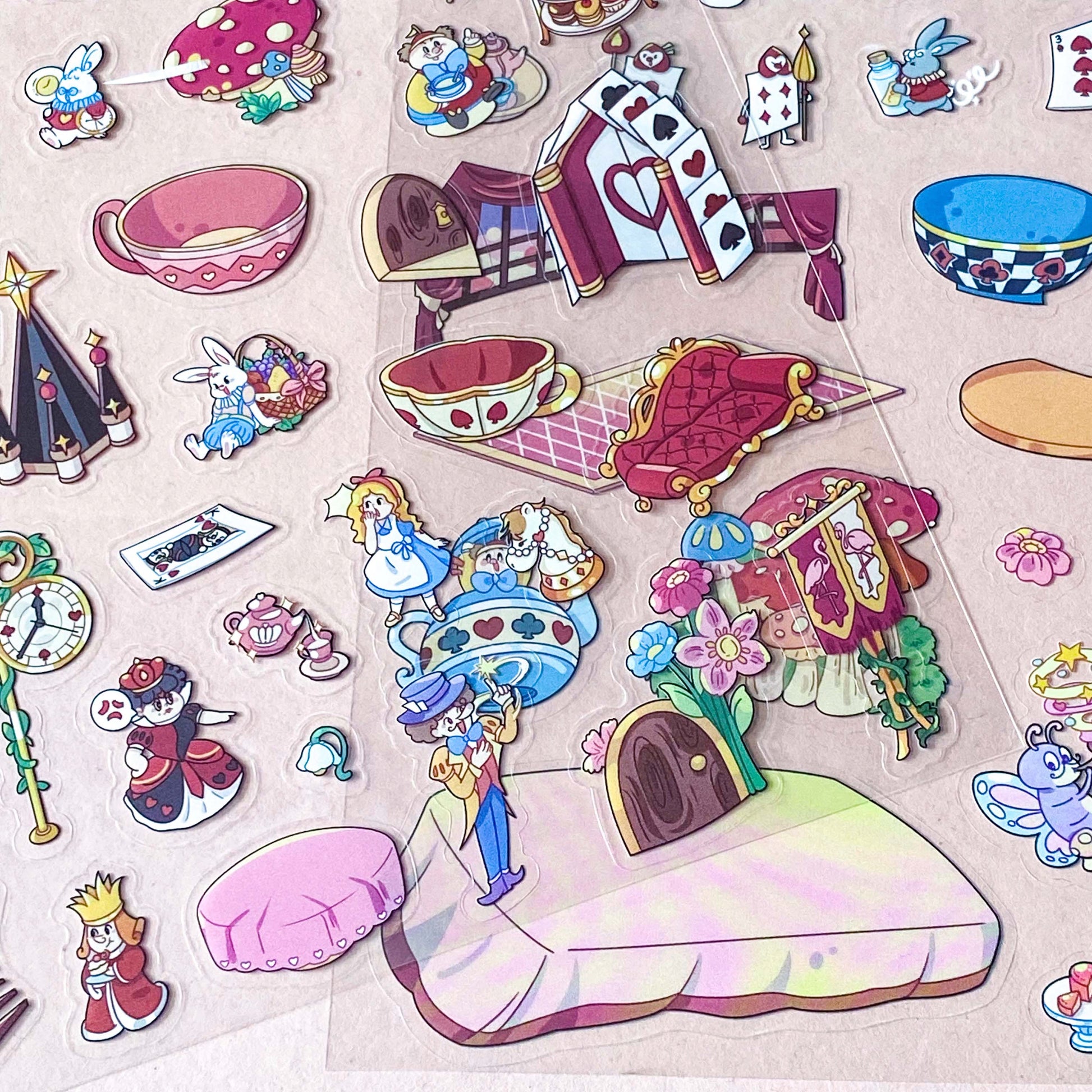 alice in wonderland sticker scene set with background card sheet and clear decorative stickers including teacup, playing cards and fantasy objects. activity creative set