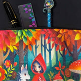 little red riding hood themed canvas zip pouch featuring colourful woodland mushrooms, autumn trees, flowers and a grey wolf companion in a storybook forest scene. red, orange, yellow and lime green colourful gift bag. 
