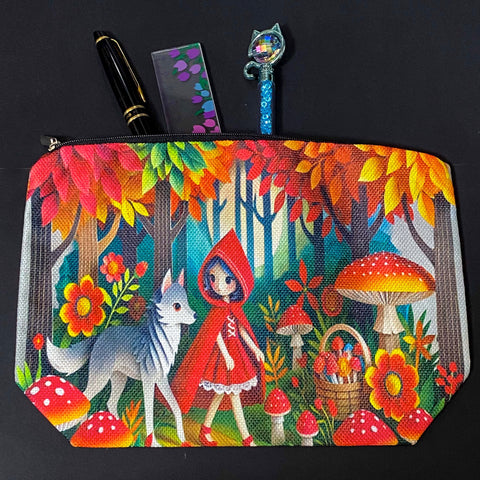 little red riding hood themed canvas zip pouch featuring colourful woodland mushrooms, autumn trees, flowers and a grey wolf companion in a storybook forest scene. red, orange, yellow and lime green colourful gift bag. 