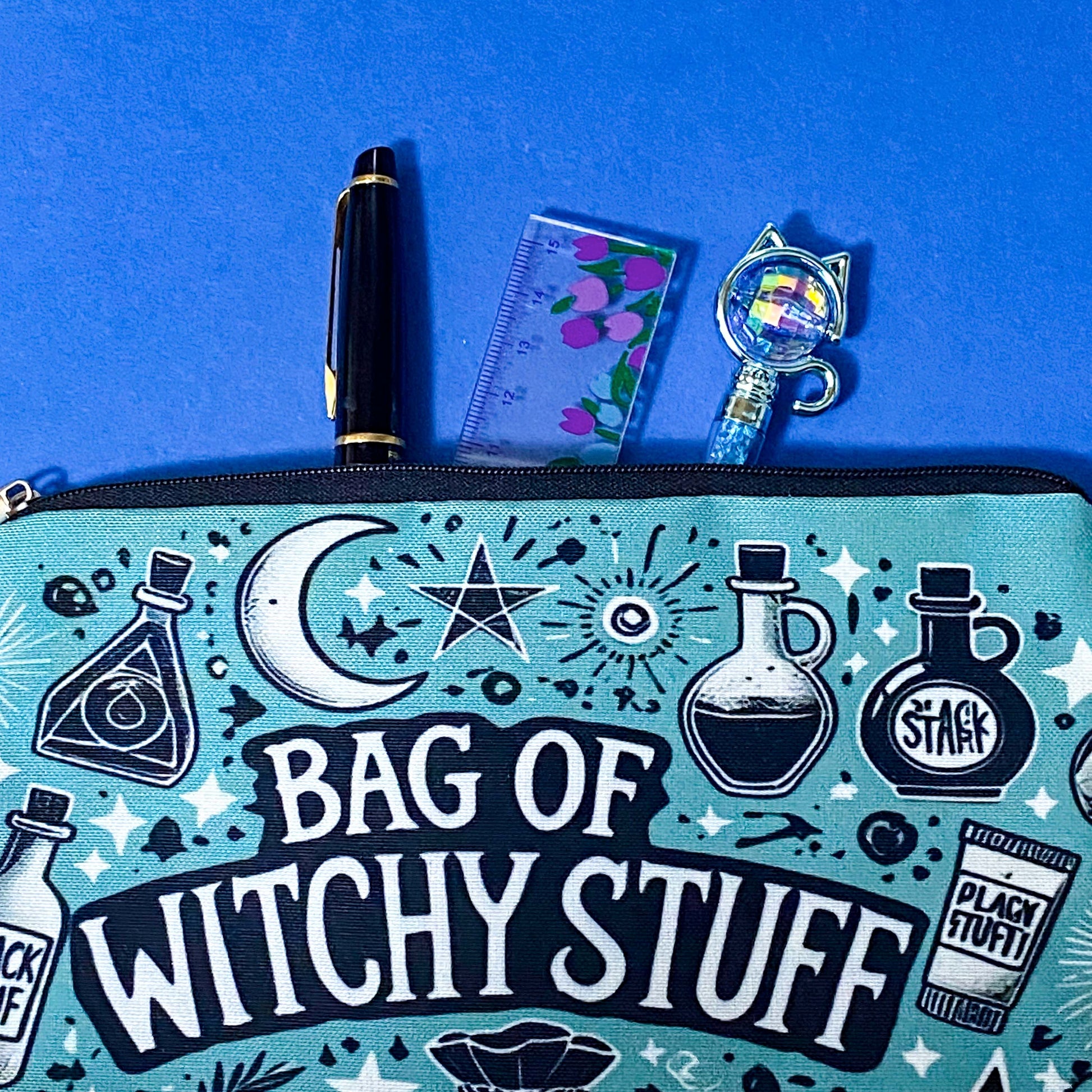 turquoise and black canvas zip pouch featuring the words "Bag of witchy stuff" surrounded by potion bottles, moons, stars, crystals and magical symbols. Uk cute and kawaii gifts shop. Bag for journaling, crystal storage or witchcraft supplies.