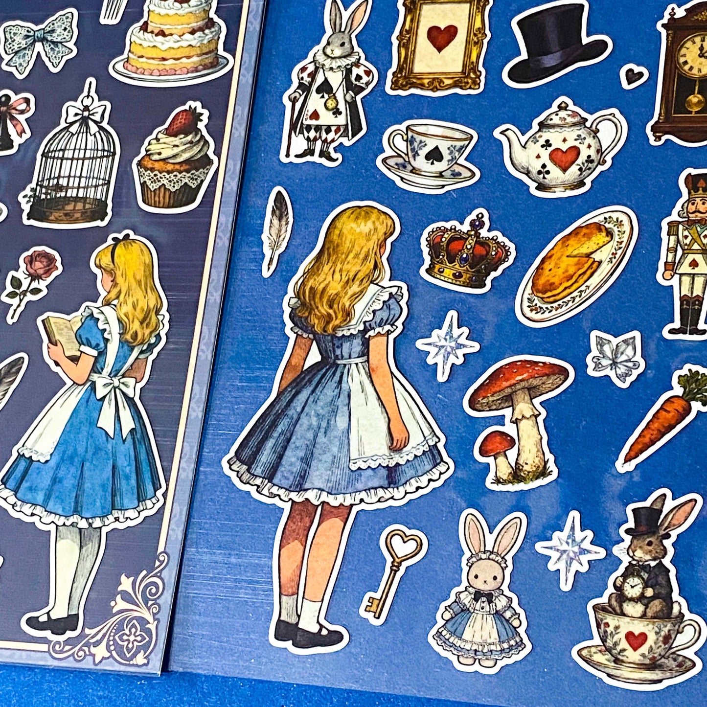 alice's adventures in wonderland matte sticker pack with two distinctive large clear decorative sheets featuring Alice, White rabbit, teacups, cakes, books, mushrooms and wonderland inspired illustrations. uk stationery shop.