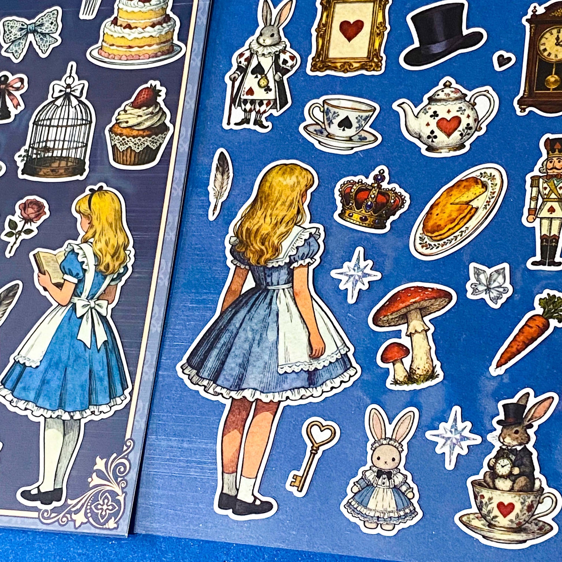 alice's adventures in wonderland matte sticker pack with two distinctive large clear decorative sheets featuring Alice, White rabbit, teacups, cakes, books, mushrooms and wonderland inspired illustrations. uk stationery shop.