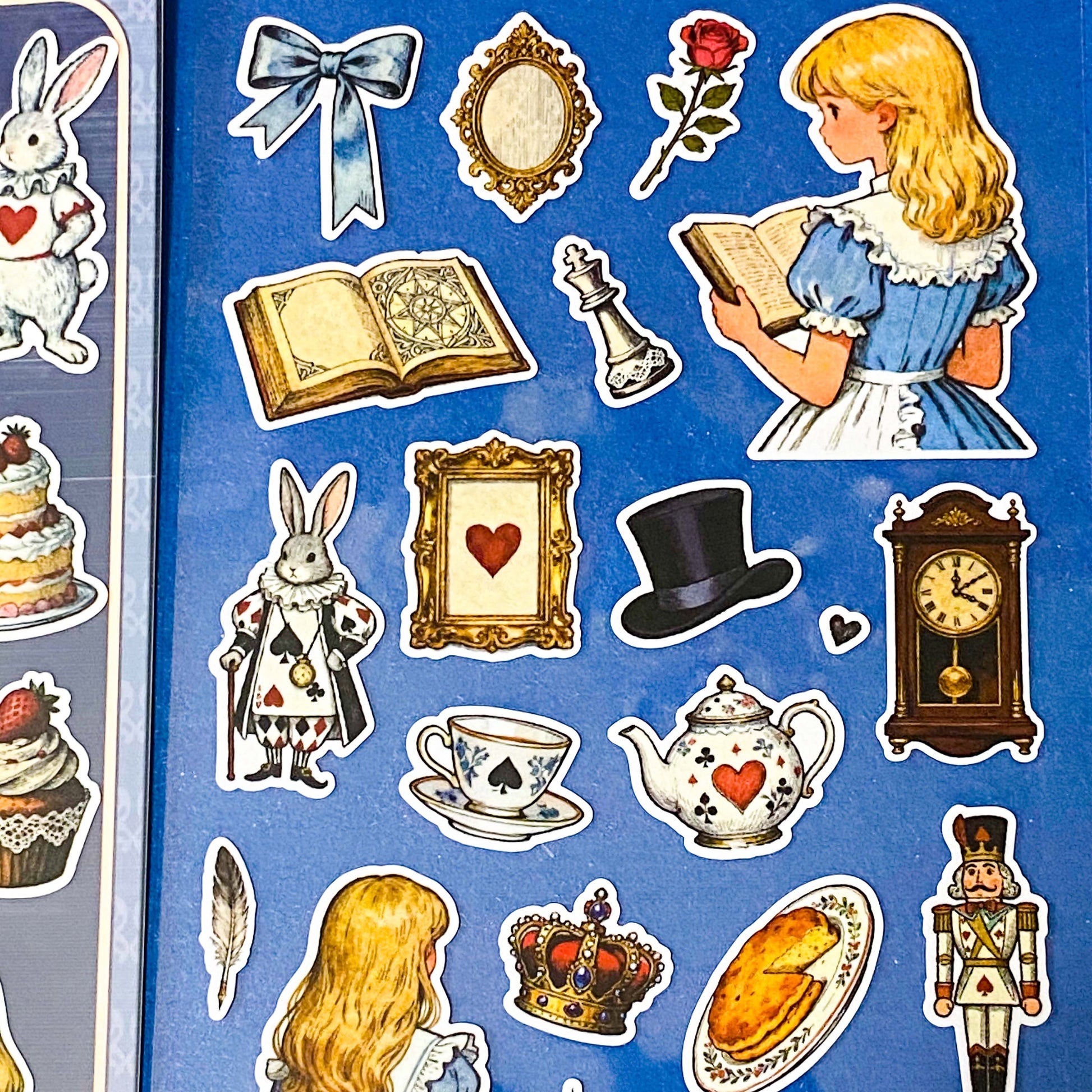 alice's adventures in wonderland matte sticker pack with two distinctive large clear decorative sheets featuring Alice, White rabbit, teacups, cakes, books, mushrooms and wonderland inspired illustrations. uk stationery shop.