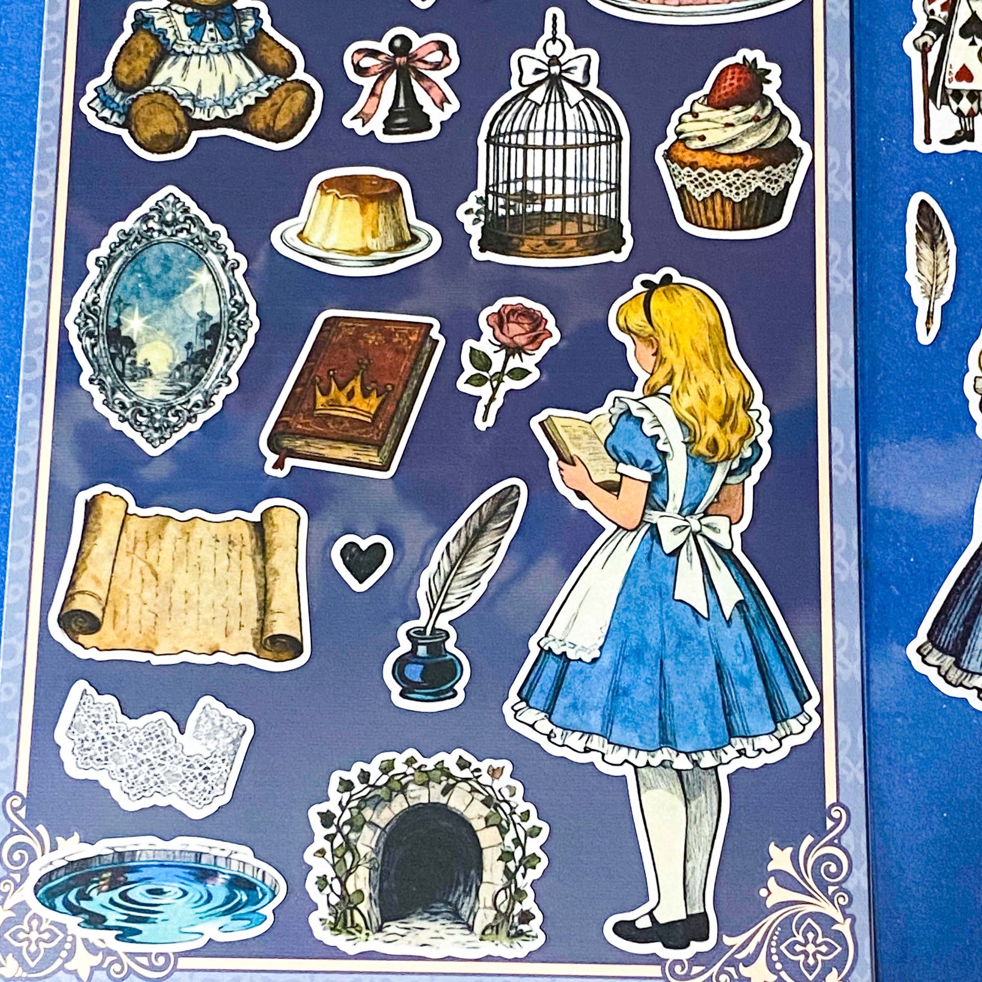 alice's adventures in wonderland matte sticker pack with two distinctive large clear decorative sheets featuring Alice, White rabbit, teacups, cakes, books, mushrooms and wonderland inspired illustrations. uk stationery shop.
