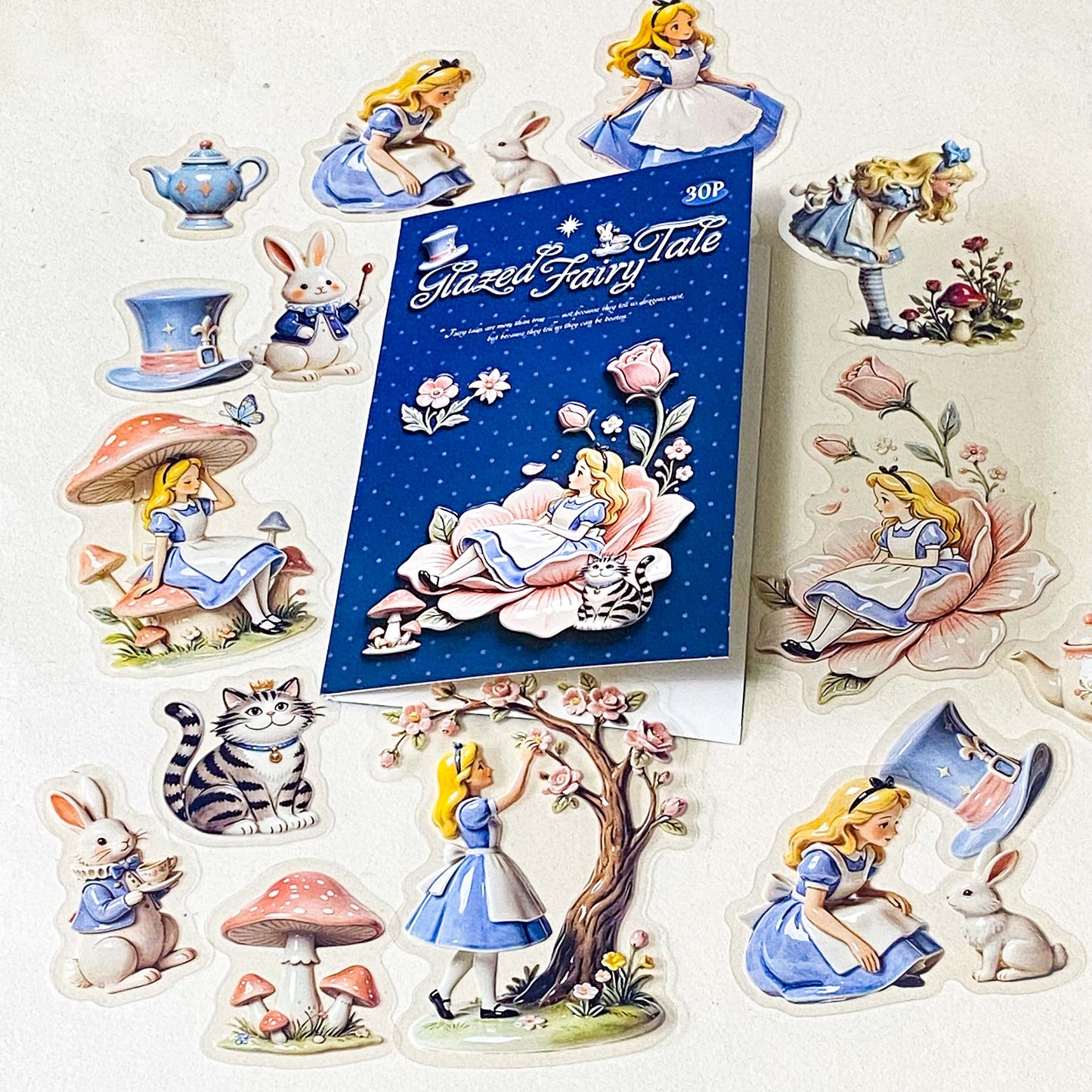 alice's glazed wonderland PET sticker pack of 30 with alice inspired ceramic effect stickers of cheshire cat, white rabbit, teapots, mushrooms and flowers in pastel pink and blue colours. uk stationery shop.