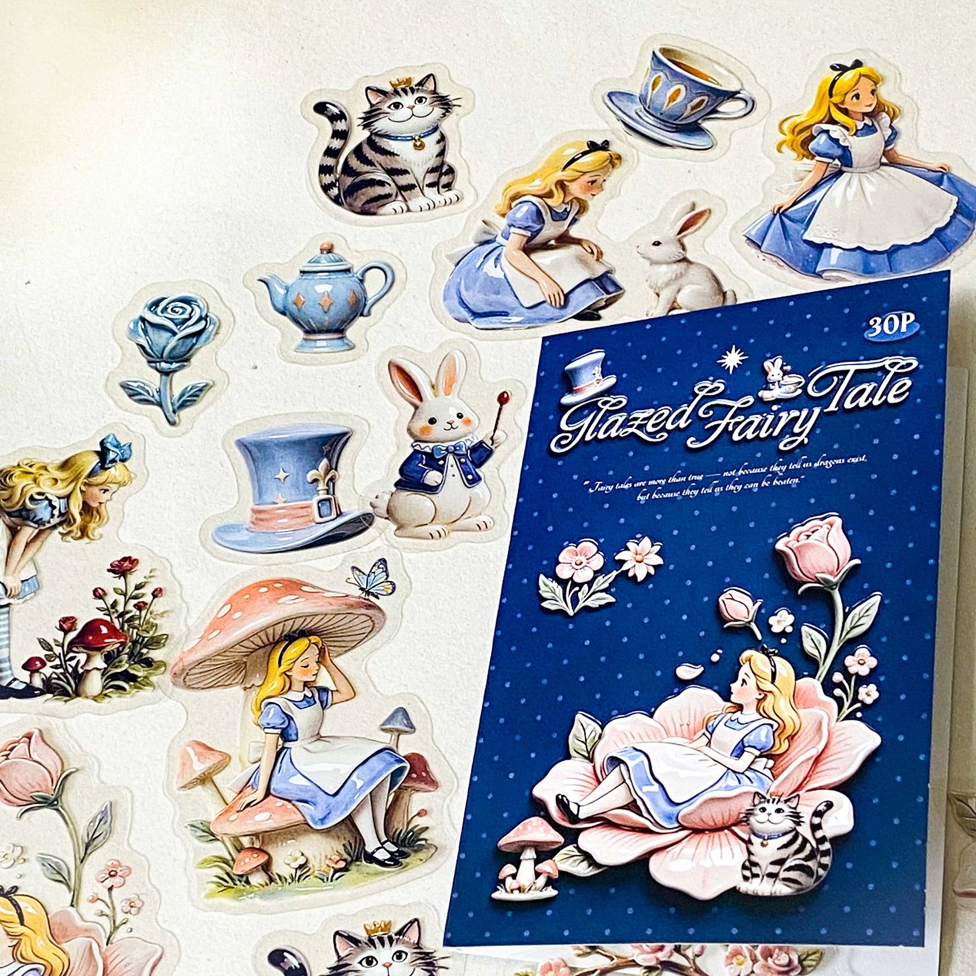 alice's glazed wonderland PET sticker pack of 30 with alice inspired ceramic effect stickers of cheshire cat, white rabbit, teapots, mushrooms and flowers in pastel pink and blue colours. uk stationery shop.