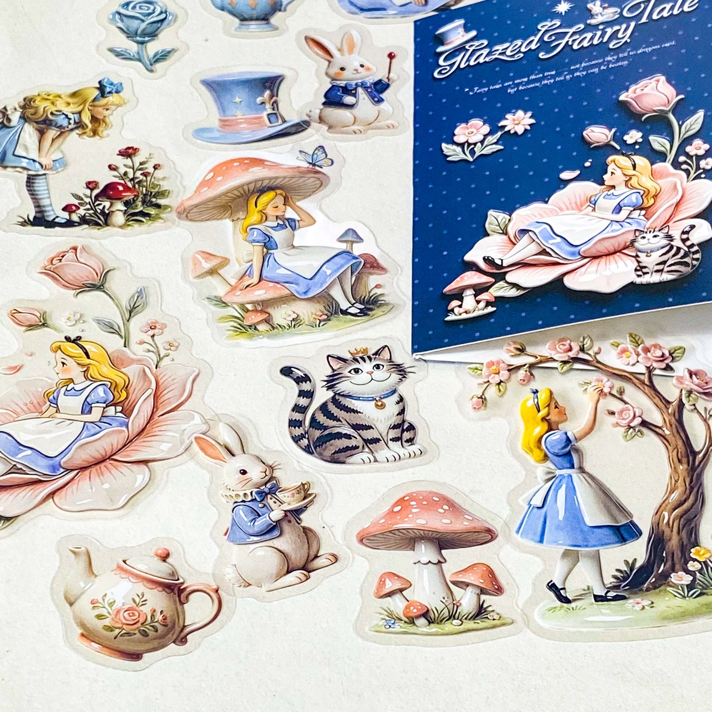 alice's glazed wonderland PET sticker pack of 30 with alice inspired ceramic effect stickers of cheshire cat, white rabbit, teapots, mushrooms and flowers in pastel pink and blue colours. uk stationery shop.