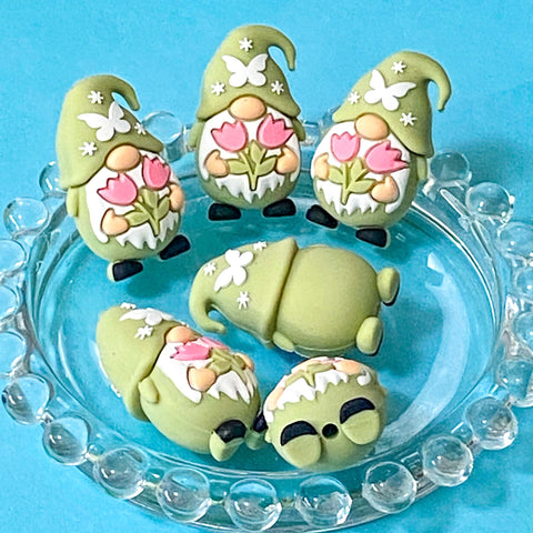 sage green gnome silicone beads with a pink tulips pattern on a blue background