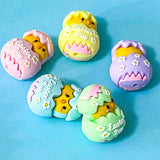 Colourful Easter-themed chick and egg-shaped large silicone beads on a blue background