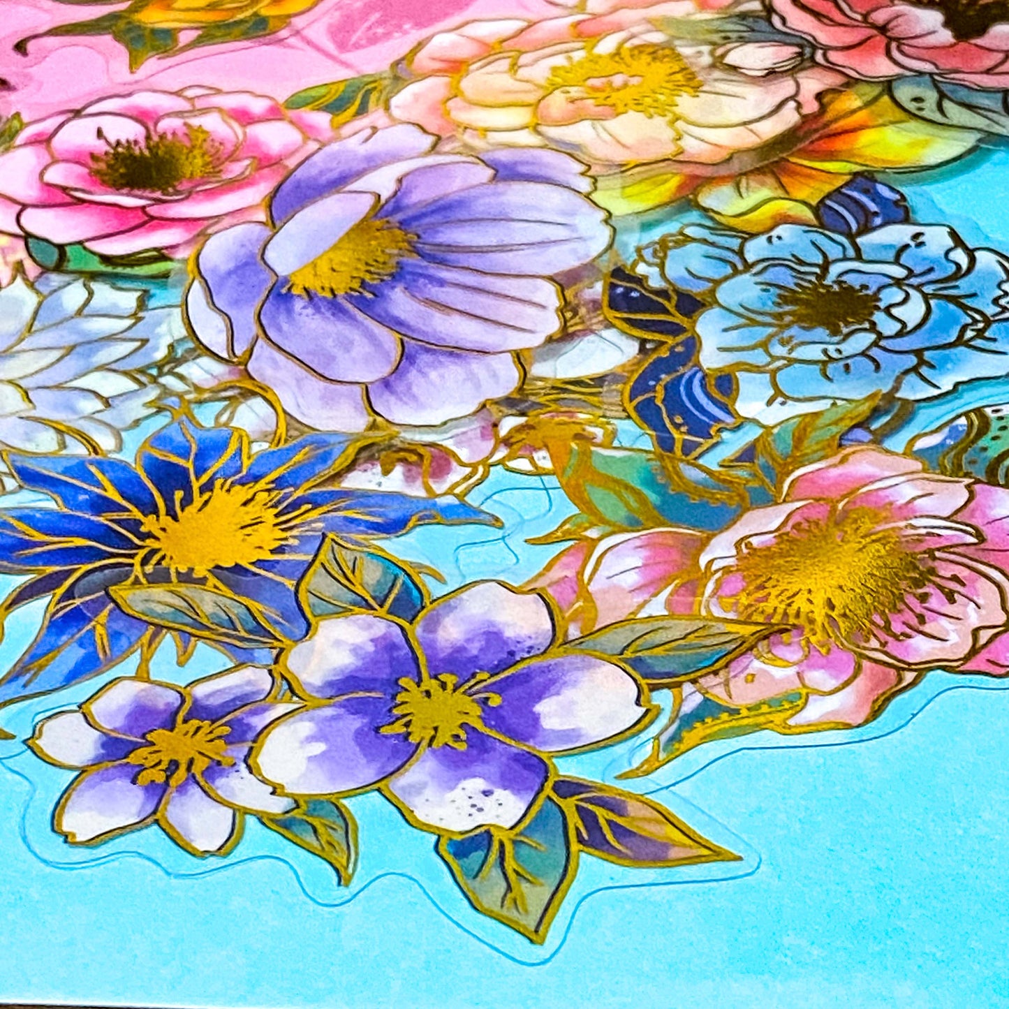 assorted large gold foil floral stickers on a turquoise background