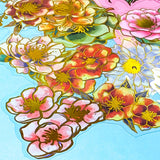 assorted large gold foil floral stickers on a turquoise background