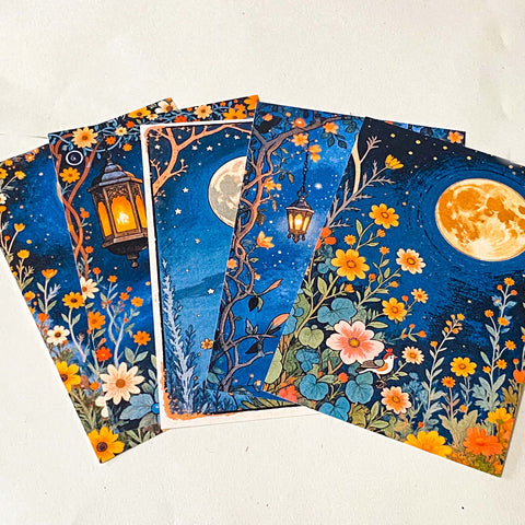 midnight garden scrapbook papers with moon, lantern and floral night sky designs arranged in fan layout
