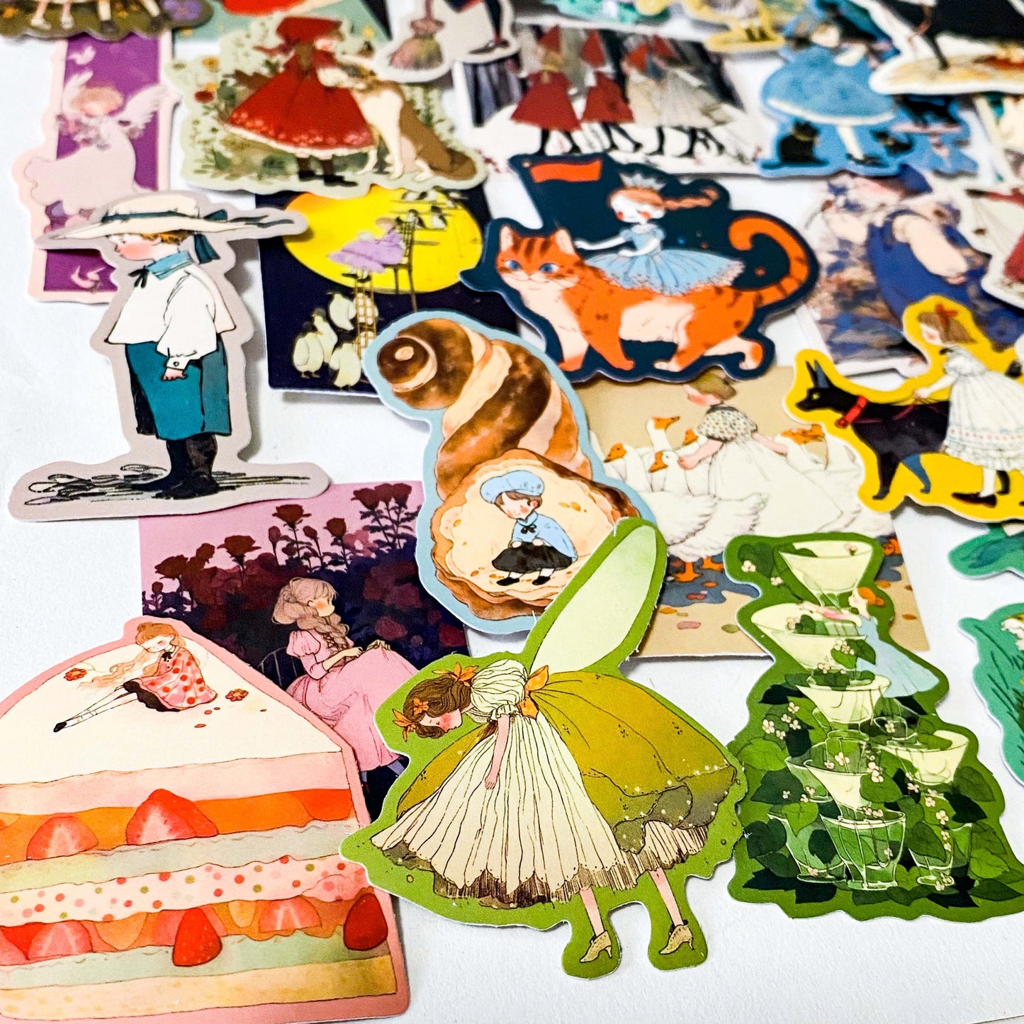 set of 50 vintage storybook style matte stickers featuring children, whimsical animals, cats and illustrated scenes in soft pastel and jewel tones for laptops and journaling