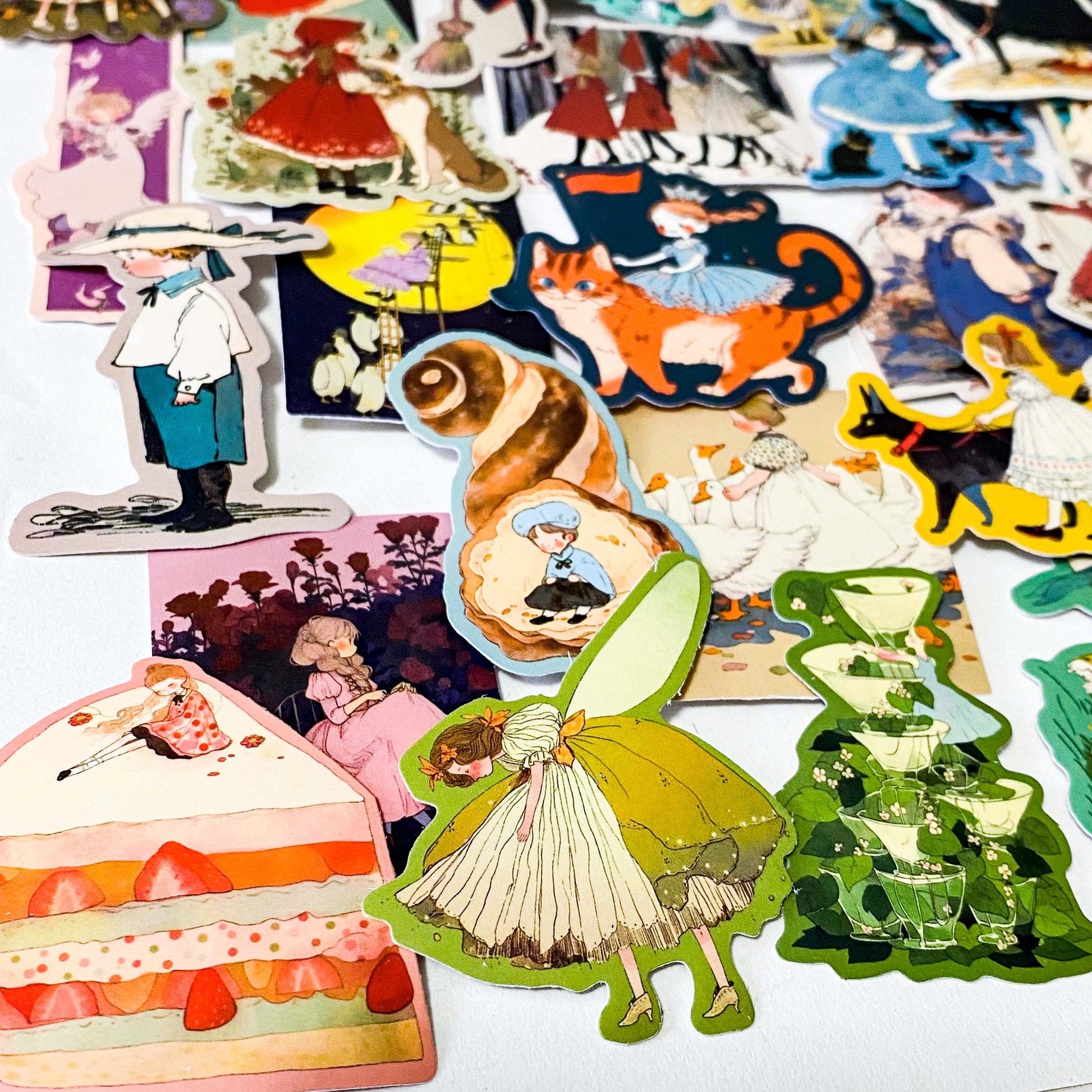 set of 50 vintage storybook style matte stickers featuring children, whimsical animals, cats and illustrated scenes in soft pastel and jewel tones for laptops and journaling