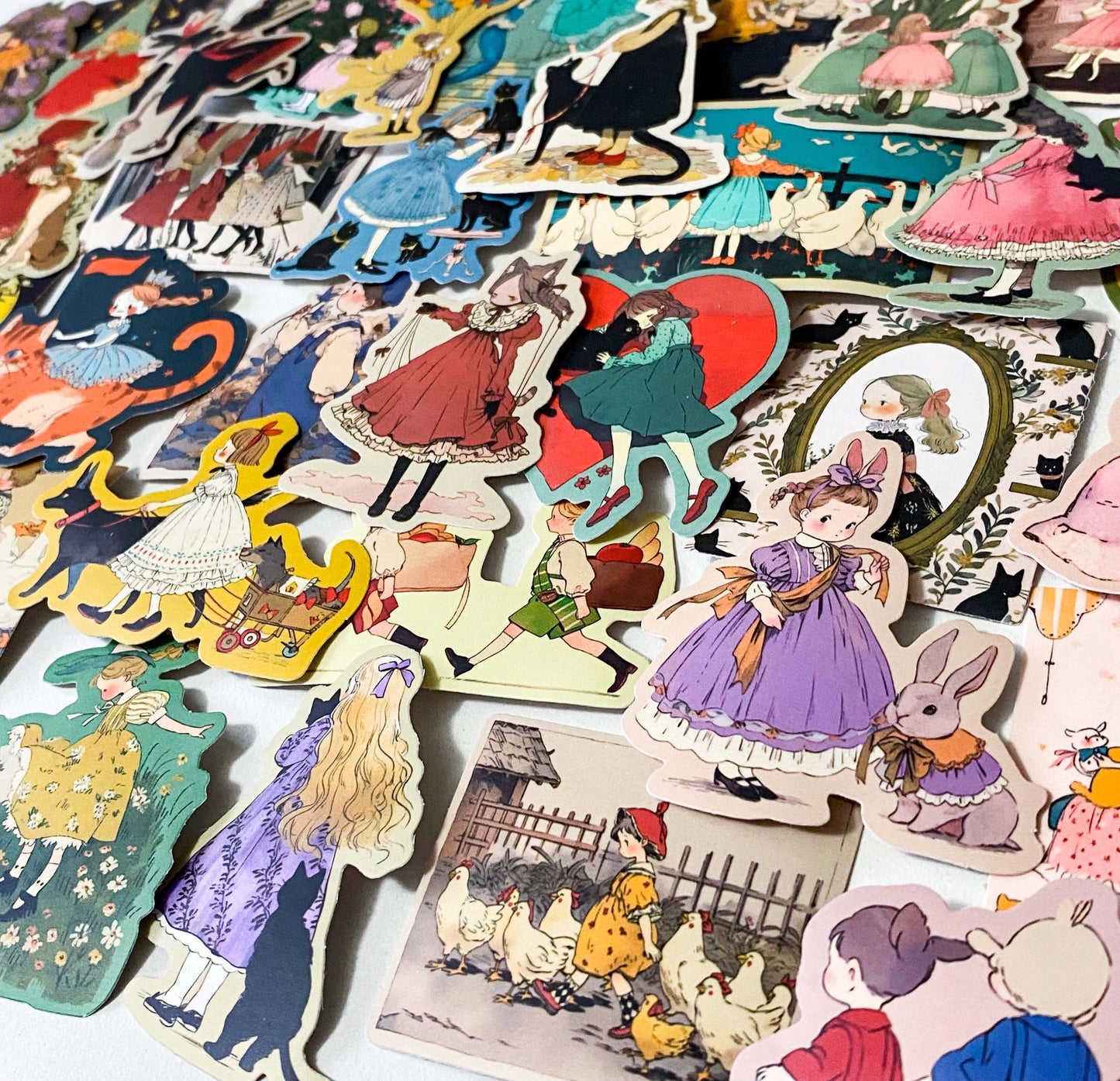 set of 50 vintage storybook style matte stickers featuring children, whimsical animals, cats and illustrated scenes in soft pastel and jewel tones for laptops and journaling