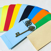 set of 10 colourful mini paper envelope pockets in mixed shades, shown open with small metal keys for scale