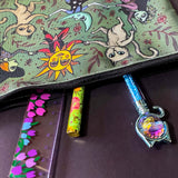 whimsical green blue zipper pouch featuring dancing cats, sun and moon characters, folk art inspired fairytale figures. witchy pencil case or journaling pouch. uk cute kawaii gifts shop.