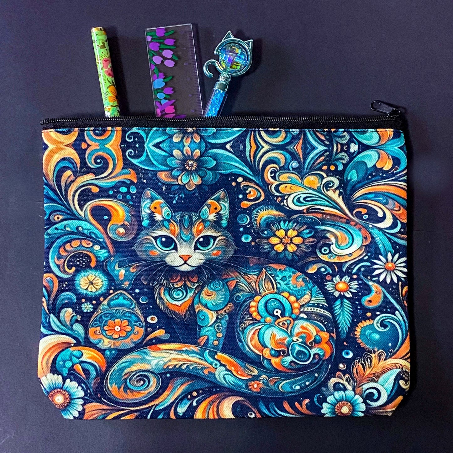 decorative folk art cat zipper canvas pouch featuring bright turquoise, navy and orange swirling floral patterns on a dark blue background. uk cute magical letterbox gifts shop. 